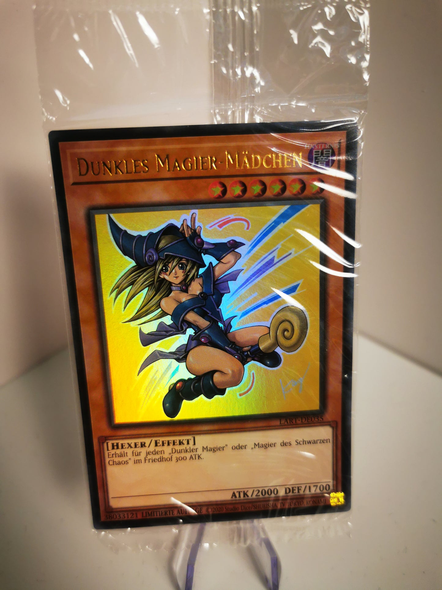 Nahaufnahme des exklusiven Lost Art Artworks vom Dunklen Magier-Mädchen, deutsche Ausgabe LART-DE035, glänzender Holo-Effekt sichtbar.